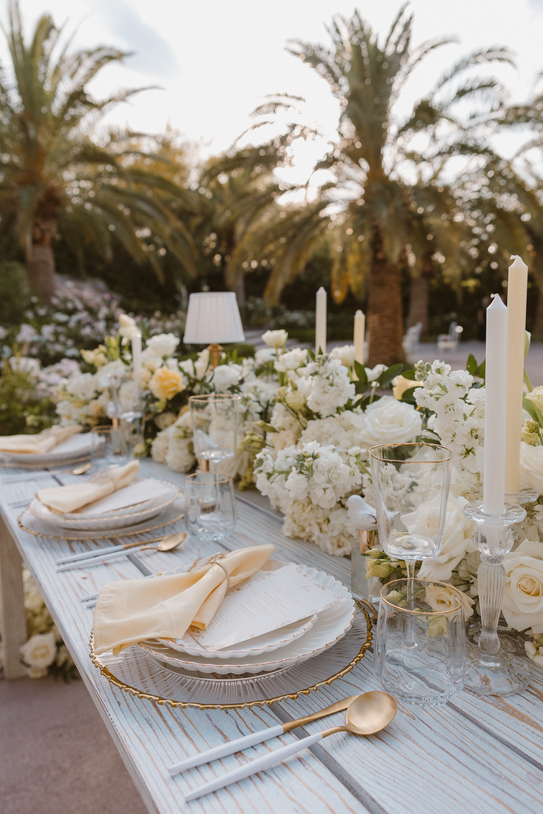 The wedding table set up with white roses, candles and flatware